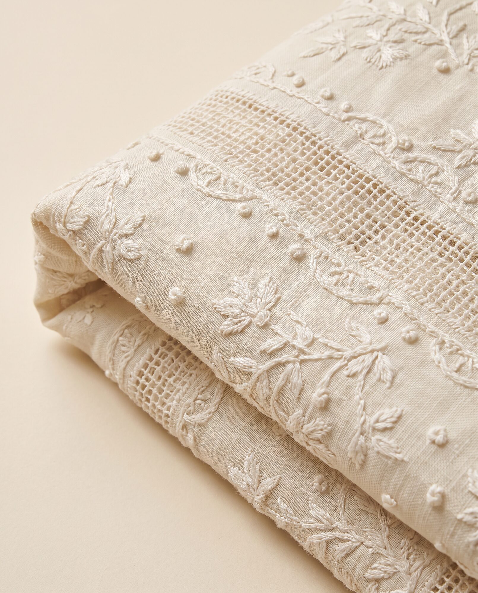 Chikankari jaali Close-up of ivory chikankari lawn showing pulled-thread jaali mesh worked by hand