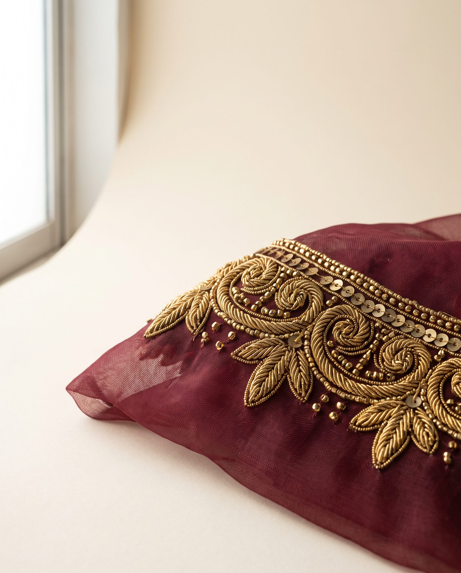 Zardozi hand work Close-up of maroon organza formal with raised zardozi hand embroidery worked on an adda frame